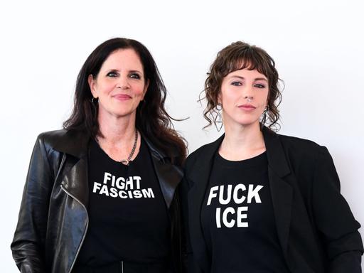 Die Filmemacherinnen Laura Poitras (links) und Rachel Lauren Mueller (rechts) ganz in schwarz gekleidet. Auf dem T-Shirt von Poitras steht "Fight Faschism" (Bekämpfe Faschismus), auf dem T-Shirt von Mueller "Fuck ICE". 