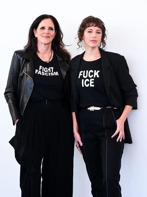 Die Filmemacherinnen Laura Poitras (links) und Rachel Lauren Mueller (rechts) ganz in schwarz gekleidet. Auf dem T-Shirt von Poitras steht "Fight Faschism" (Bekämpfe Faschismus), auf dem T-Shirt von Mueller "Fuck ICE". 