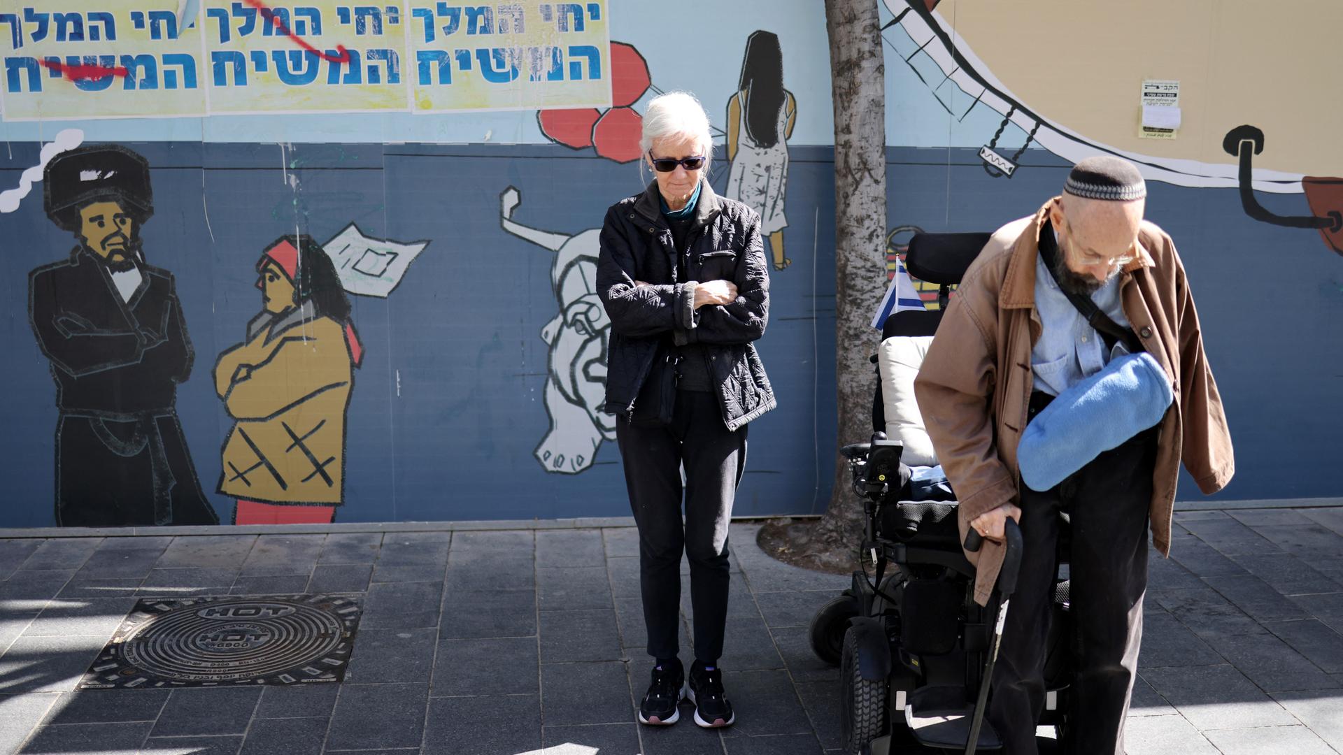 Menschen stehen in Schweigen auf der Straße während Sirenen heulen. Menschen stehen in Schweigen auf der Straße während Sirenen heulen.