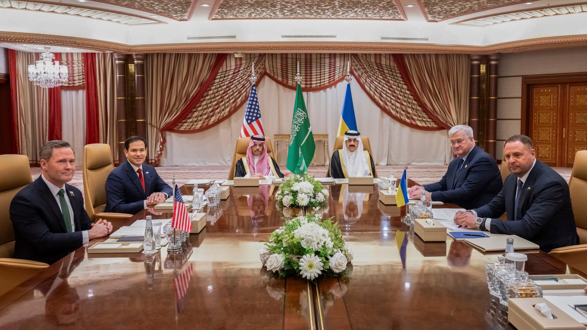 Im Dschidda sitzen Mike Waltz und  Marco Rubio (USA), der saudi-arabische Außenminister Prinz Faisal bin Farhan und Sicherheitsberater Mosaad bin Mohammad al-Aiban sowie der ukrainische Außenminister Andrii Sybiha und Andriy Yermak an einem Tisch.