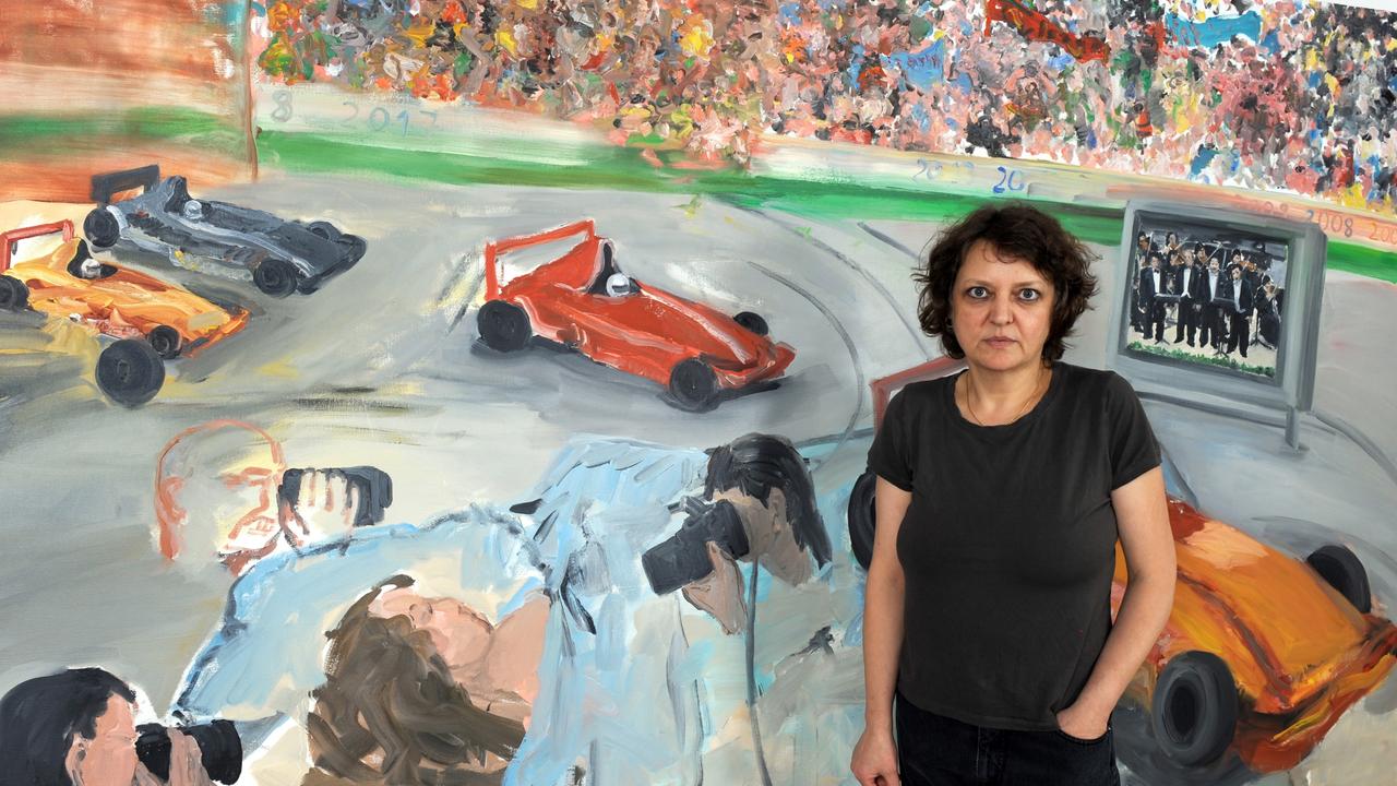 Die Künstlerin Cordula Güdemann steht im Jahr 2008 in ihrem Atelier in Stuttgart vor einem großformatigen Bild mit Rennautos darauf