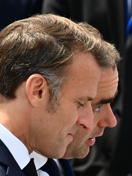 Die Köpfe von Emmanuel Macron und Sébastien Lecornu sind am 14. Juli 2025 bei einem Bad in der Menge auf den Champs-Élysées in Paris nebeneinader zu sehen.