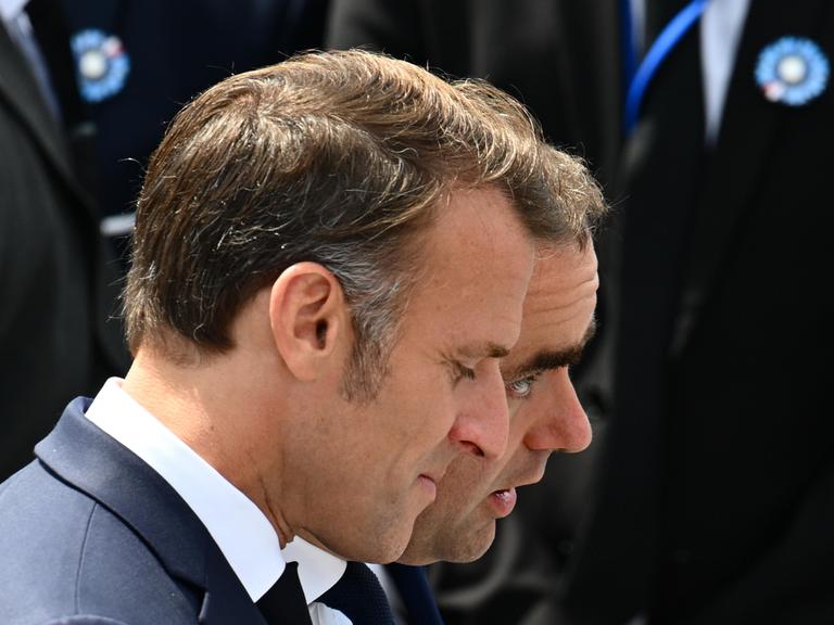 Die Köpfe von Emmanuel Macron und Sébastien Lecornu sind am 14. Juli 2025 bei einem Bad in der Menge auf den Champs-Élysées in Paris nebeneinader zu sehen.