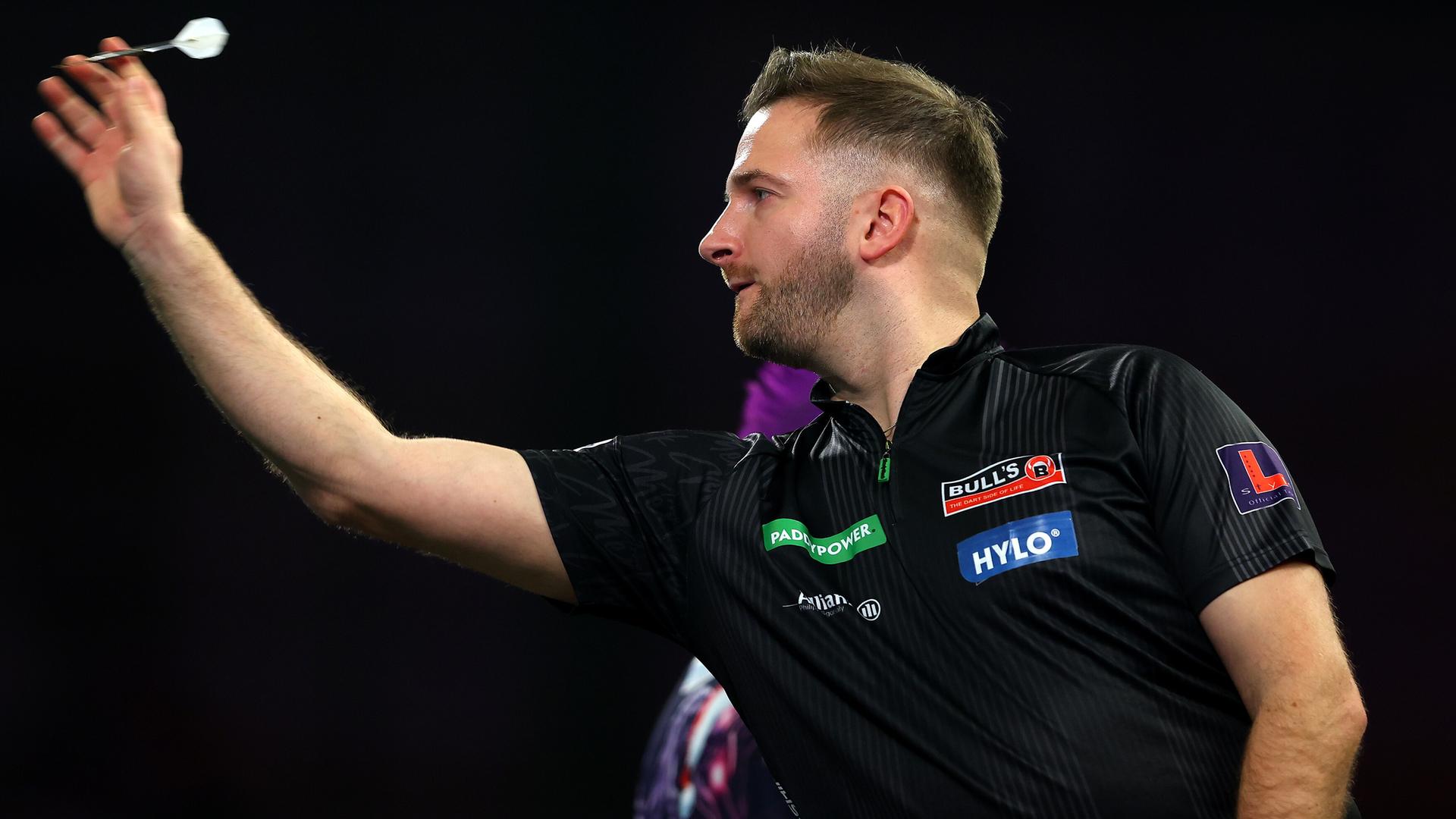 Arno Merk wirft einen Pfeil.