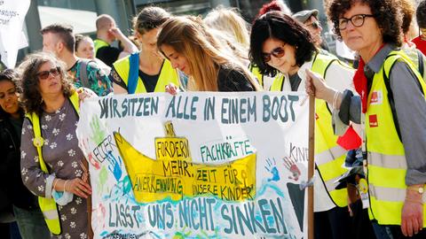 Auf einer Kundgebung der Gewerkschaft Verdi in Gelsenkirchen halten mehrere Frauen ein Plakat. 