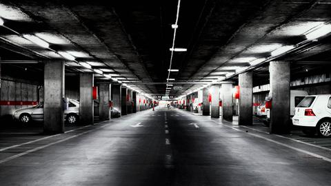 Eine verwinkelte Tiefgarage mit vereinzelten Autos darin.