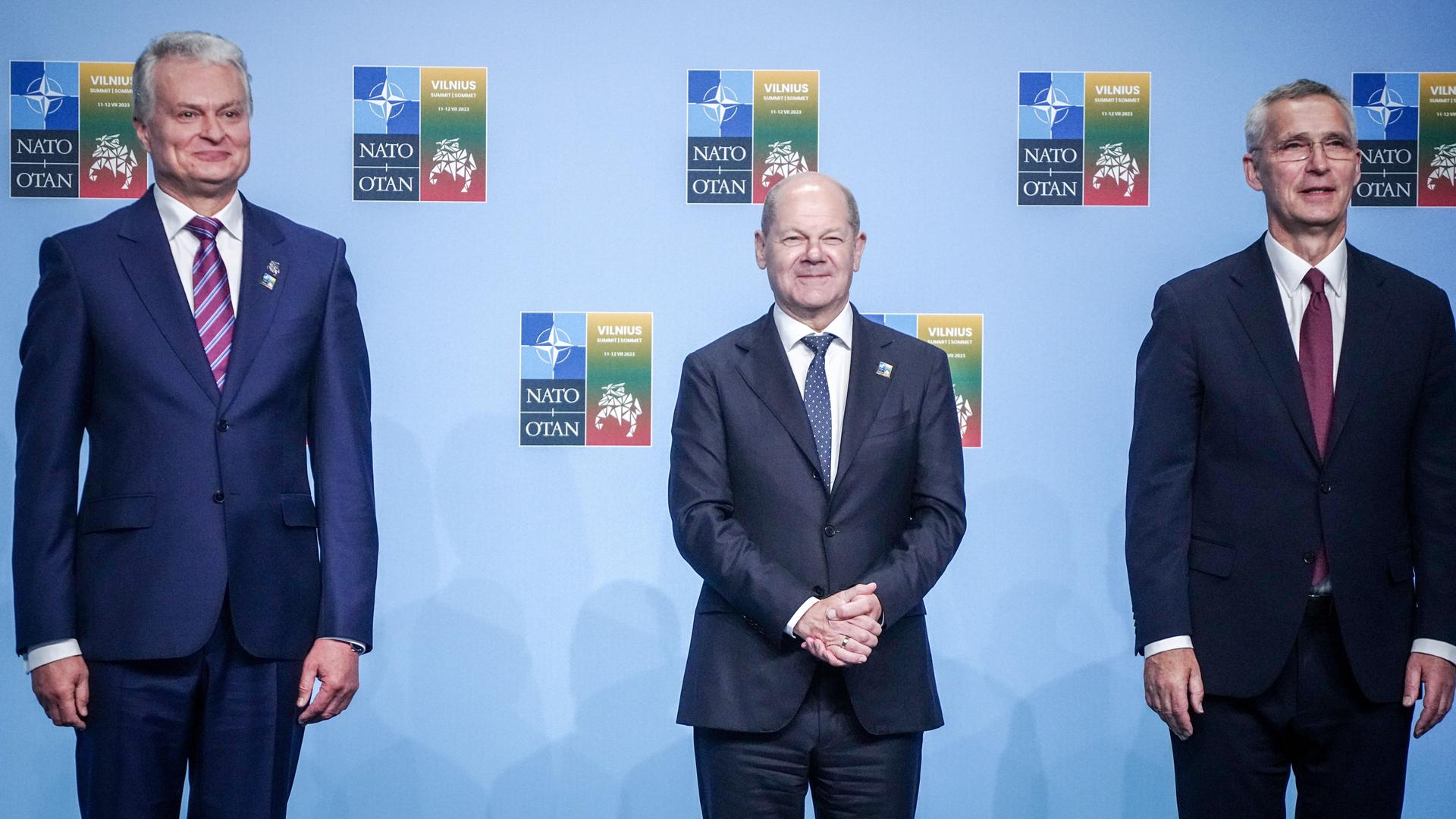 Litauen, Vilnius: Bundeskanzler Olaf Scholz (SPD) wird beim Nato-Gipfel von Jens Stoltenberg (r), Nato-Generalsekretär, und Gitanas Nauseda (l), Präsident von Litauen, empfangen.