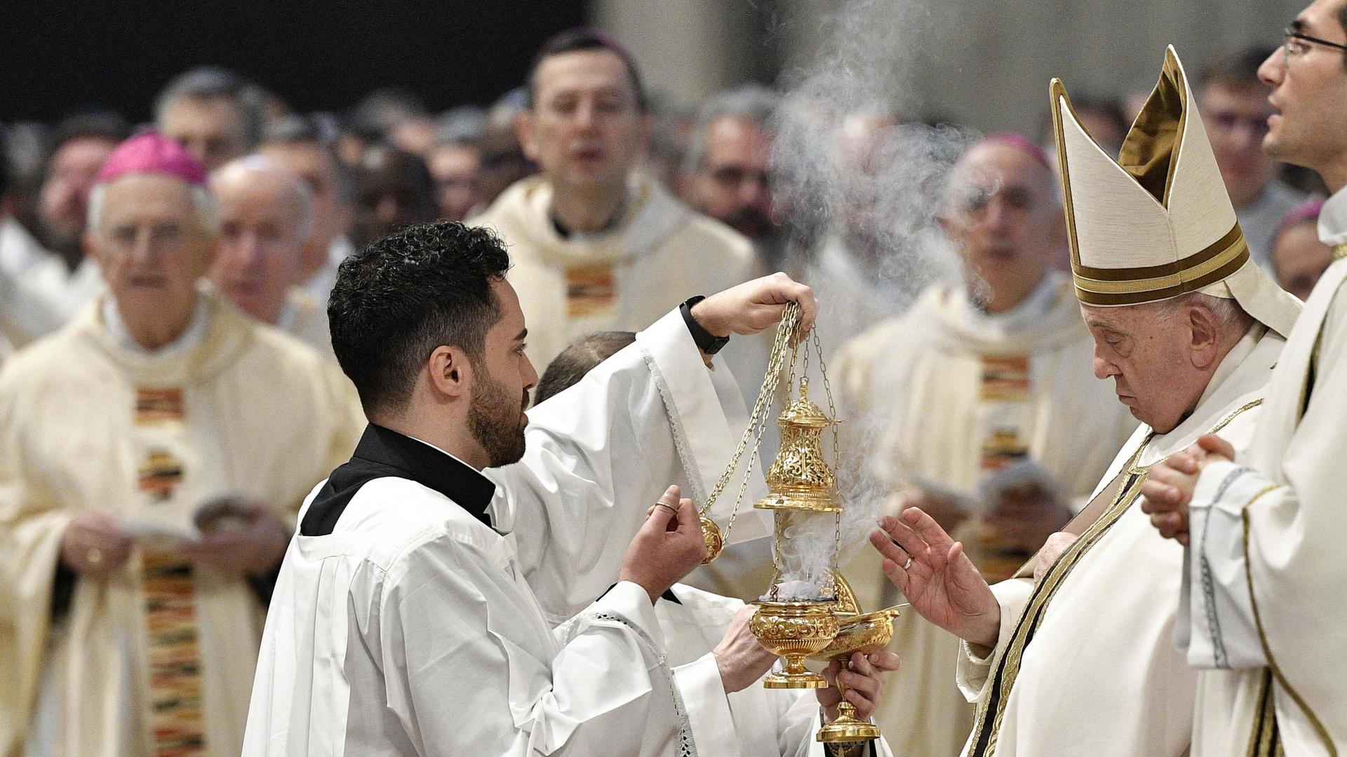 Papst Franziskus feiert mit anderen Priestern einen Ostern-Gottesdienst. Ein Priester hält ein Gefäß mit Weihrauch.