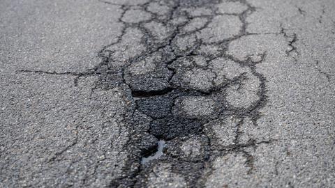 Risse und Schlaglöcher auf einer asphaltierten Straße. Risse und Schlaglöcher auf einer asphaltierten Straße.