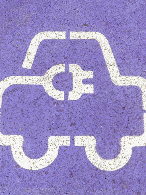 Nahaufnahme eines weißen Symbols für Elektrofahrzeuge, das auf eine violette Asphaltoberfläche gemalt ist Nahaufnahme eines weißen Symbols für Elektrofahrzeuge, das auf eine violette Asphaltoberfläche gemalt ist