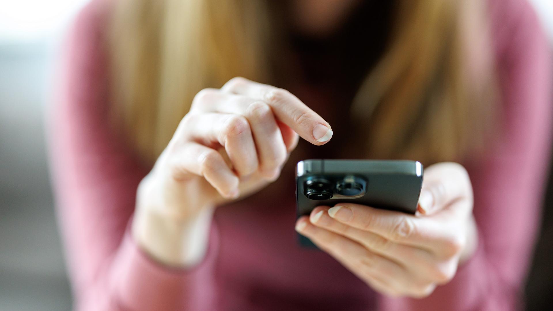 Eine junge Frau benutzt ein Smartphone.