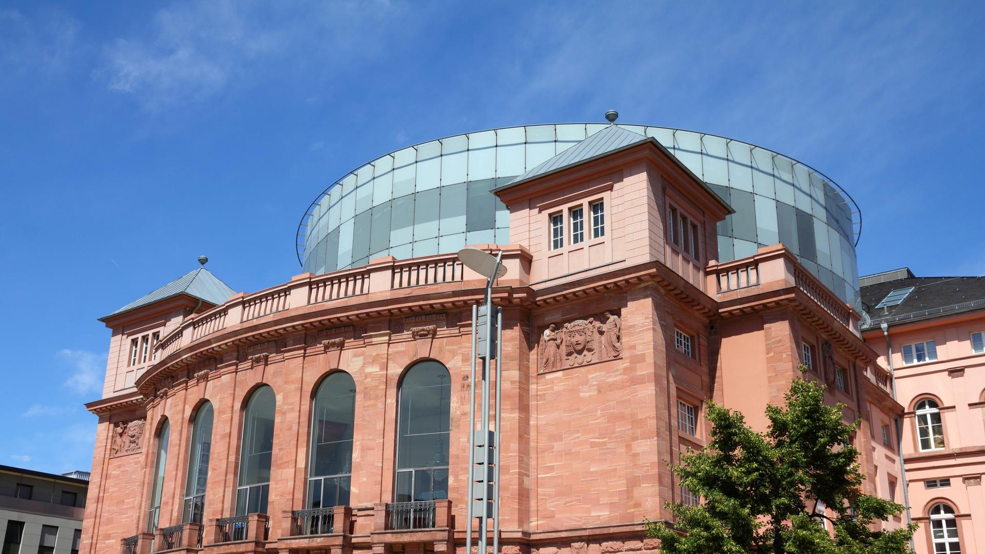 Das Foto zeigt das Staatstheater in Mainz, ein älteres Gebäude verkleidet mit roten Ziegeln und einem Glasdach. Das Foto zeigt das Staatstheater in Mainz, ein älteres Gebäude verkleidet mit roten Ziegeln und einem Glasdach.