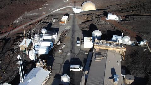 Die Station Mauna Loa auf Hawaii. Seit 1958 messen Wissenschaftler die CO2-Konzentration in der Luft, es ist die älteste Kohlendioxid-Messstation der Welt. Die karge Landschaft und die Gebäude wirken, als handele es sich um eine Marsstation.