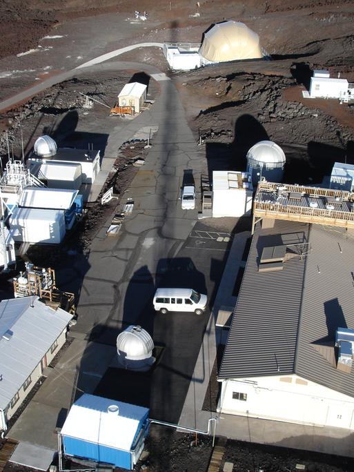 Die Station Mauna Loa auf Hawaii. Seit 1958 messen Wissenschaftler die CO2-Konzentration in der Luft, es ist die älteste Kohlendioxid-Messstation der Welt. Die karge Landschaft und die Gebäude wirken, als handele es sich um eine Marsstation.