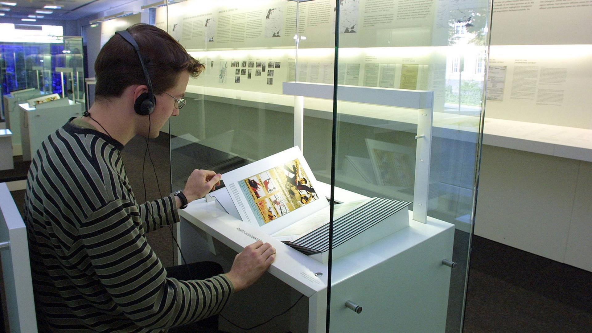 Eine junge Person betrachtet ein Exponat der Ausstellung "Verbrechen der Wehrmacht".