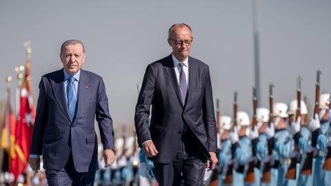 Zwei Männer schreiten entlang von Soldaten.