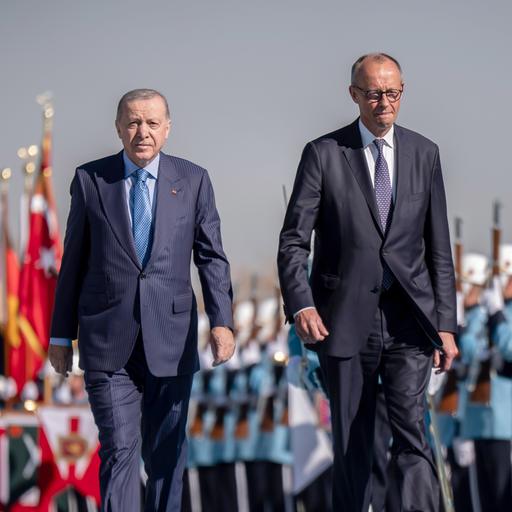 Zwei Männer schreiten entlang von Soldaten.