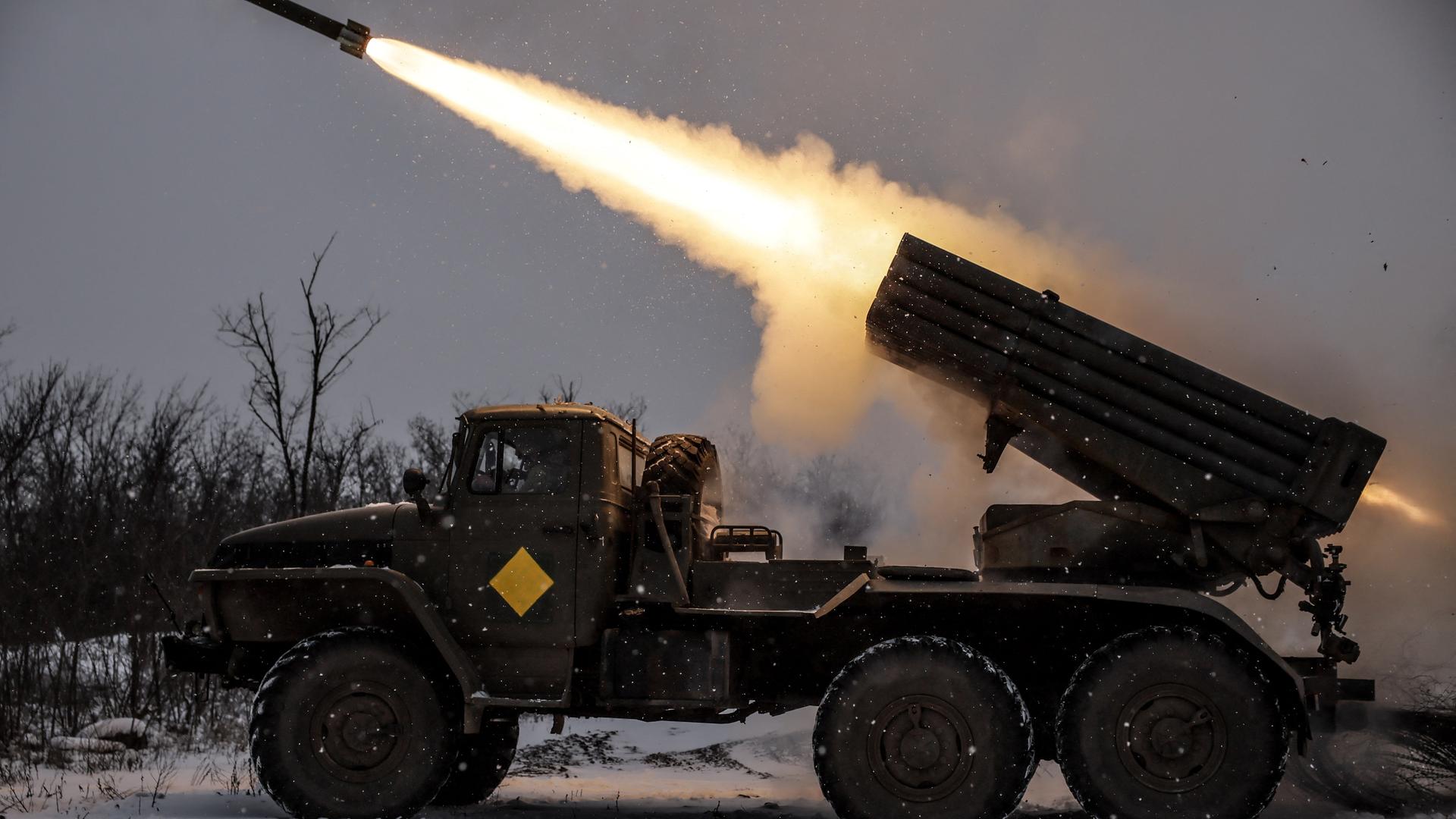 Ukrainische Soldaten feuern eine Rakete von einem Kriegsfahrzeug ab.