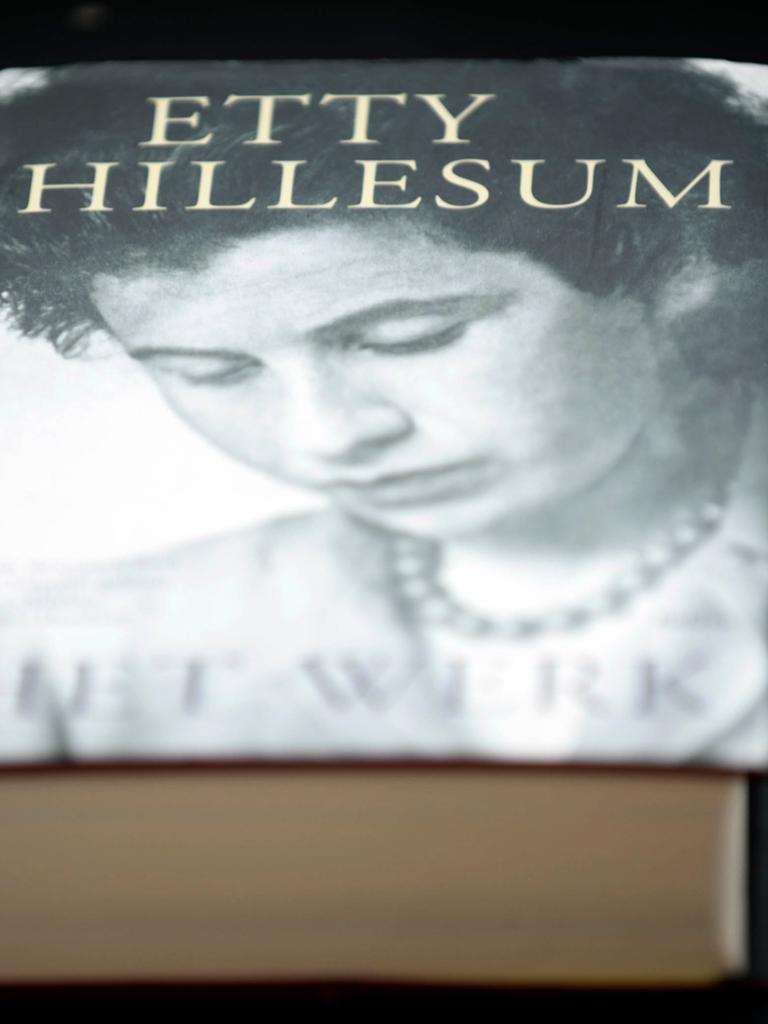 Ein Buch von Etty Hillesum liegt auf einem Tisch. Auf dem Cover zeigt es ihr Porträt in Schwarzweiß.
