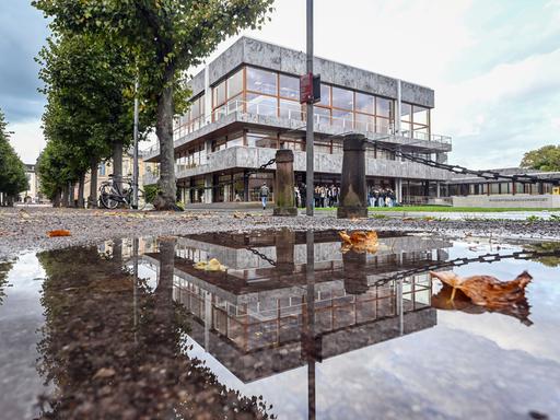 Das Bundesverfassungsgericht in Karlsruhe spiegelt sich in einer Pfütze wider. 