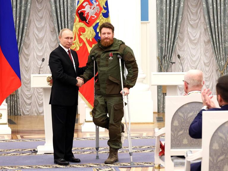 Der russische Präsident Wladimir Putin schüttelt die Hand des Militärblogger Semyon Pegov im Dezember 2022 bei der Verleihung eines Ehrenordens.