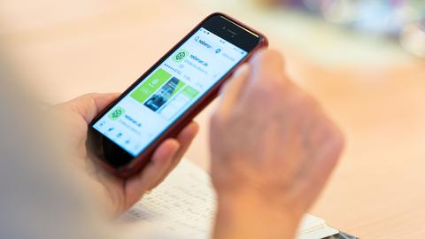 Eine Person hält ein Smartphone in der Hand, auf dessen Display die App nebenan.de geöffnet ist. Eine Person hält ein Smartphone in der Hand, auf dessen Display die App nebenan.de geöffnet ist.