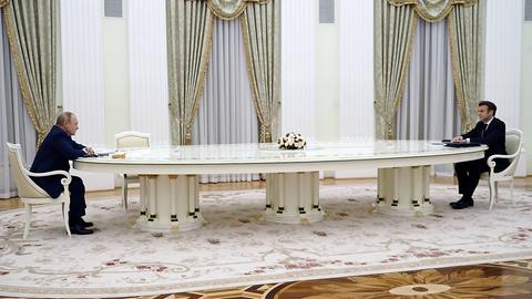 Putin und Macron sitzen an einem sehr langen Tisch in Moskau.