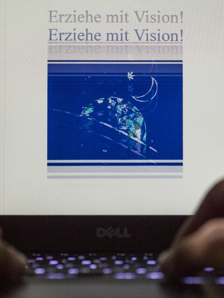Ein Mann öffnet ein Handbuch der Sekte «Organische Christus Generation.» In dem Buch «Erziehe mit Vision!» beschreibt Ivo Sasek die Prinzipien der von ihm propagierten Kindererziehung. Sasek ist Gründer der Sekte «Organische Christus Generation».
