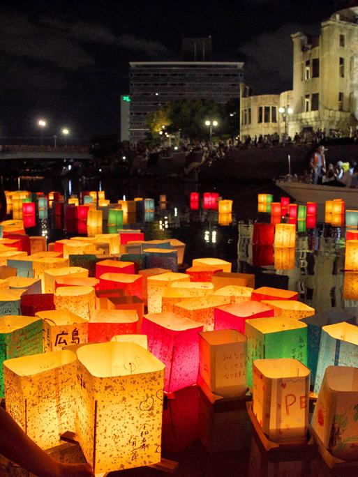 Anlässlich des 78. Jahrestages des Abwurfs der Atombombe auf Hiroshima am 06.08.2023 lassen Menschen am Friedensdenkmal in Hiroshima bunte Papierlaternen im Fluss Motoyasu schwimmen. 