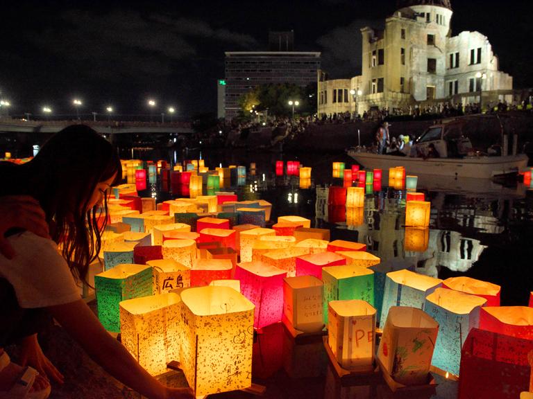 Anlässlich des 78. Jahrestages des Abwurfs der Atombombe auf Hiroshima am 06.08.2023 lassen Menschen am Friedensdenkmal in Hiroshima bunte Papierlaternen im Fluss Motoyasu schwimmen. 