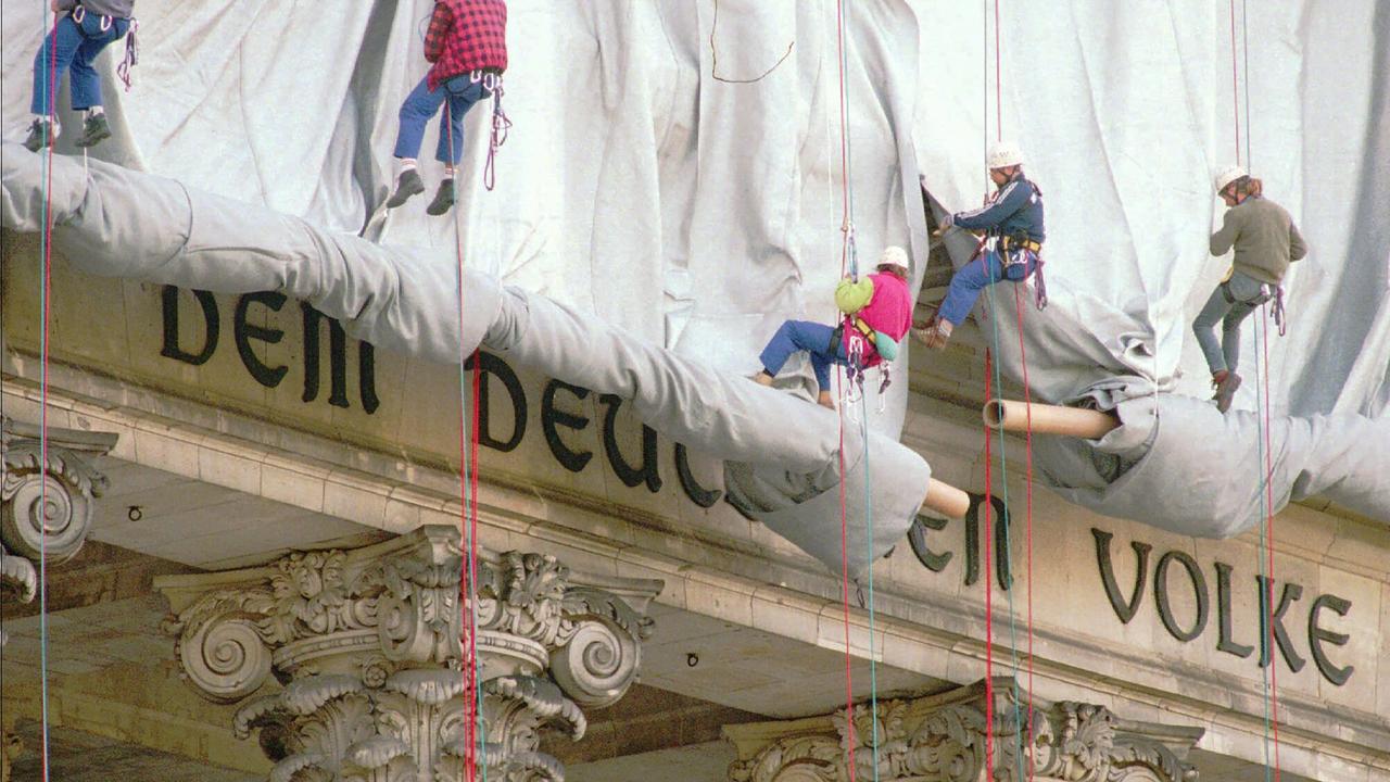 Fassadenkletterer lassen silberfarbenen Stoff am Reichstagsgebäude über die Inschrift "Dem deutschen Volke" runter