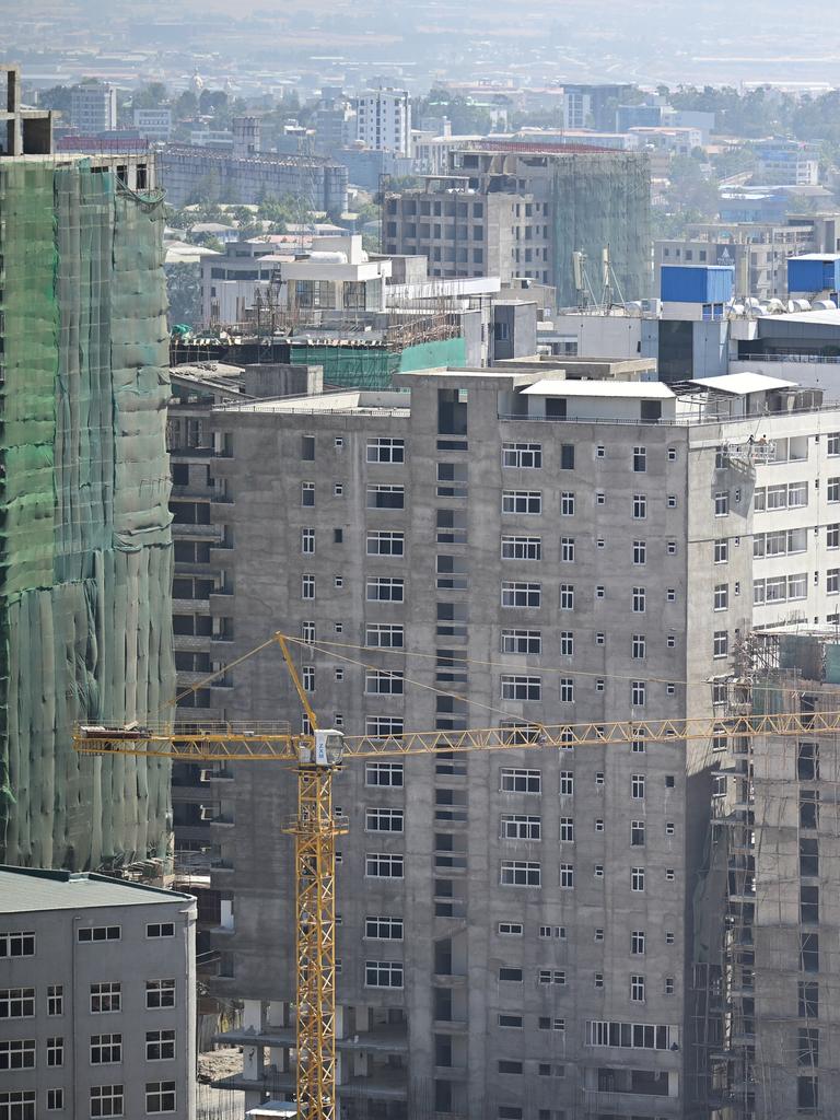 Ein Baukran steht vor teilweise fertig gestellten Hochhäusern.