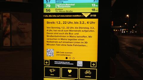 Blick auf die gelbe Videotafel mit schwarzer Schrift. Es ist dunkel. 