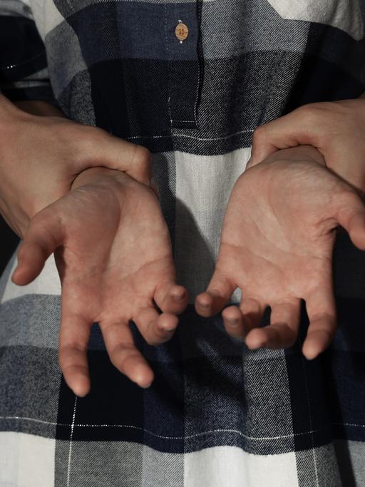 Ein Mann greift gewaltsam nach den Handgelenken einer Frau
