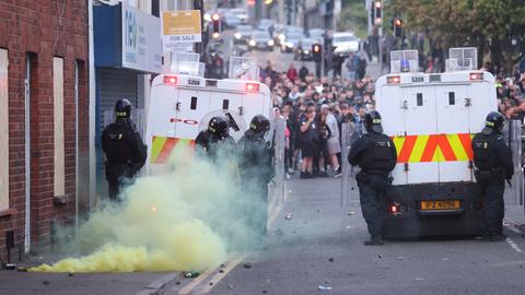 Eine gelbe Fackel raucht, nachdem sie von der Menge in Ballymena, Nordirland, auf die Polizei geworfen wurde.