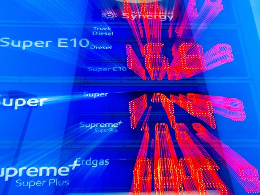 Auf einer Preistafel einer Tankstelle werden am Morgen die aktuellen Literpreise für Kraftstoff angezeigt. (Aufnahme mit langer Belichtungszeit und Zoomeffekt).