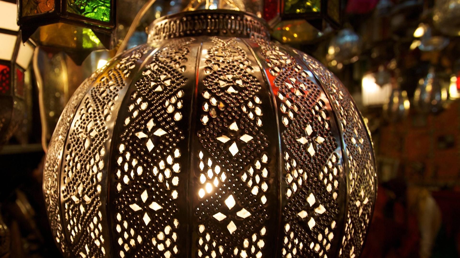Ein mit orientalischen Mustern reich verzierter, kugelförmiger Lampenschirm.