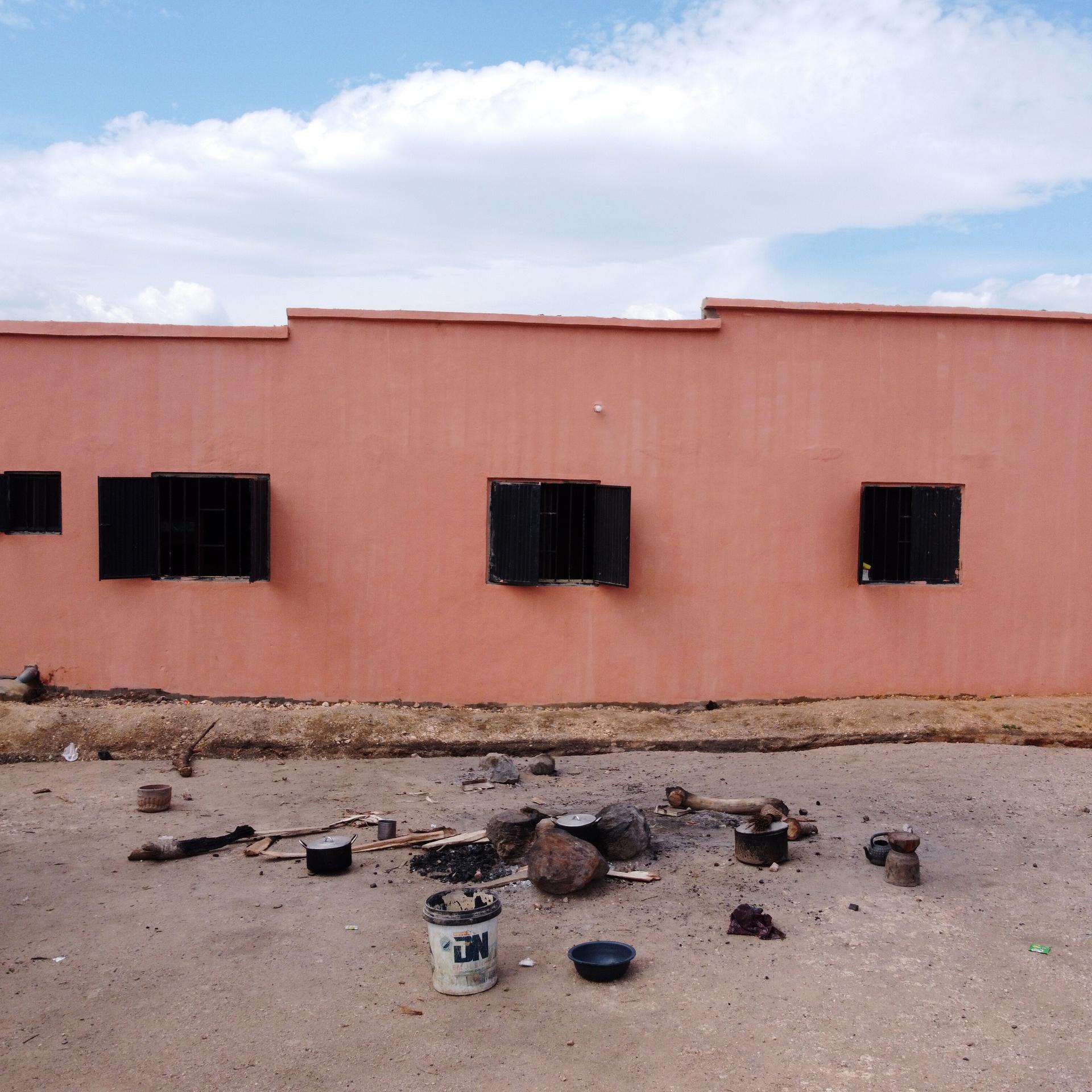 Vor einem Gebäude liegen verkohlte Trümmer.