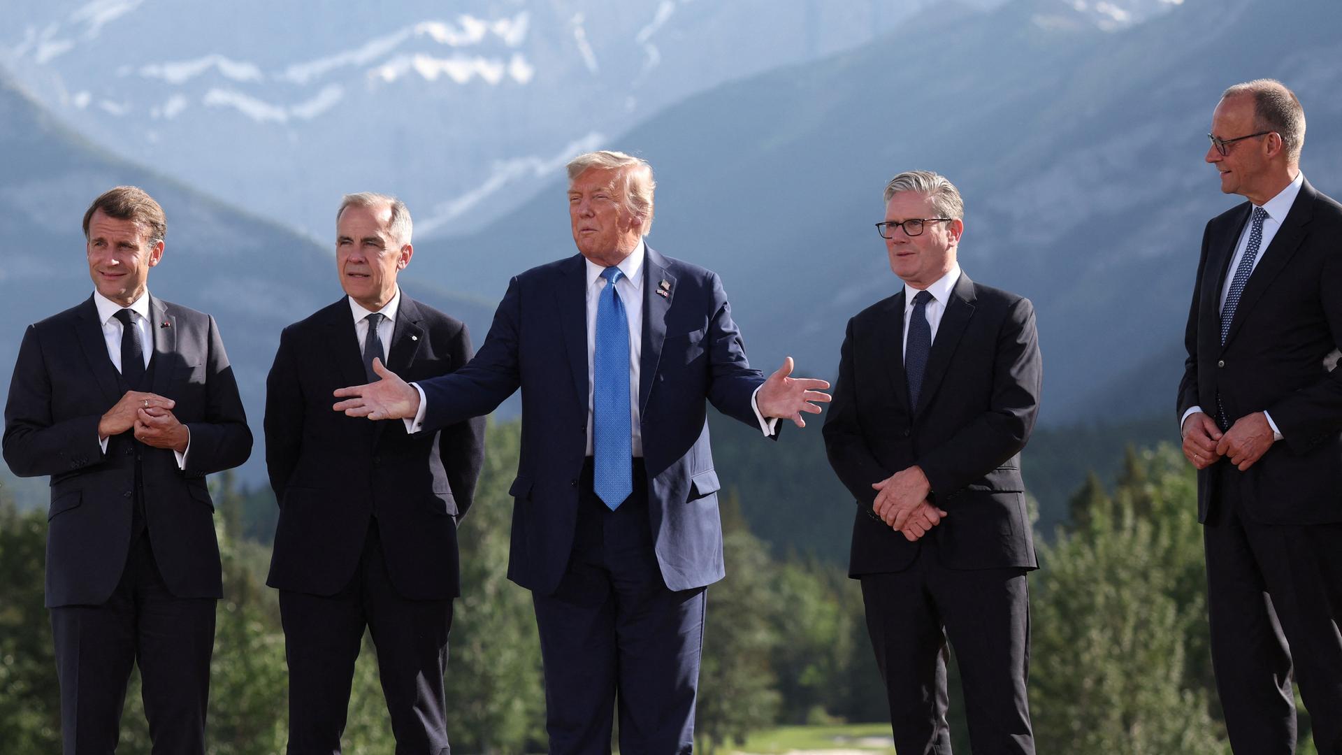Emmanuel Macron, Mark Carney, Donald Trump, Keir Starmer und Friedrich Merz stehen vor den Bergen Alaskas beim G7-Gipfel zusammen