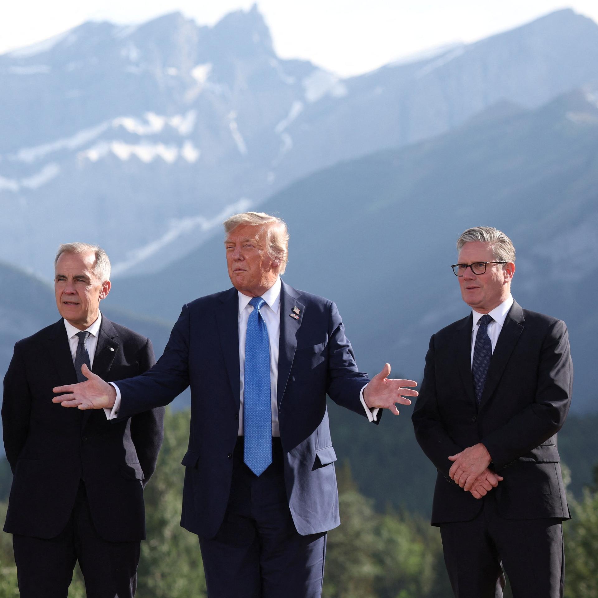 Emmanuel Macron, Mark Carney, Donald Trump, Keir Starmer und Friedrich Merz stehen vor den Bergen Alaskas beim G7-Gipfel zusammen