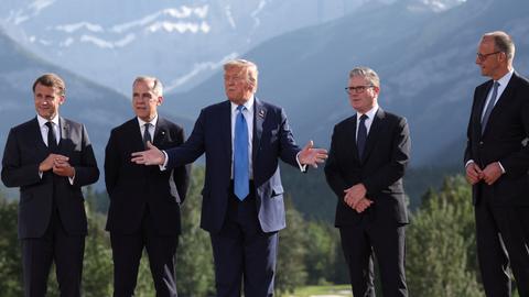 Emmanuel Macron, Mark Carney, Donald Trump, Keir Starmer und Friedrich Merz stehen vor den Bergen Alaskas beim G7-Gipfel zusammen