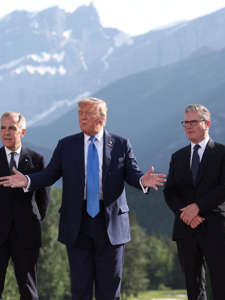 Emmanuel Macron, Mark Carney, Donald Trump, Keir Starmer und Friedrich Merz stehen vor den Bergen Alaskas beim G7-Gipfel zusammen