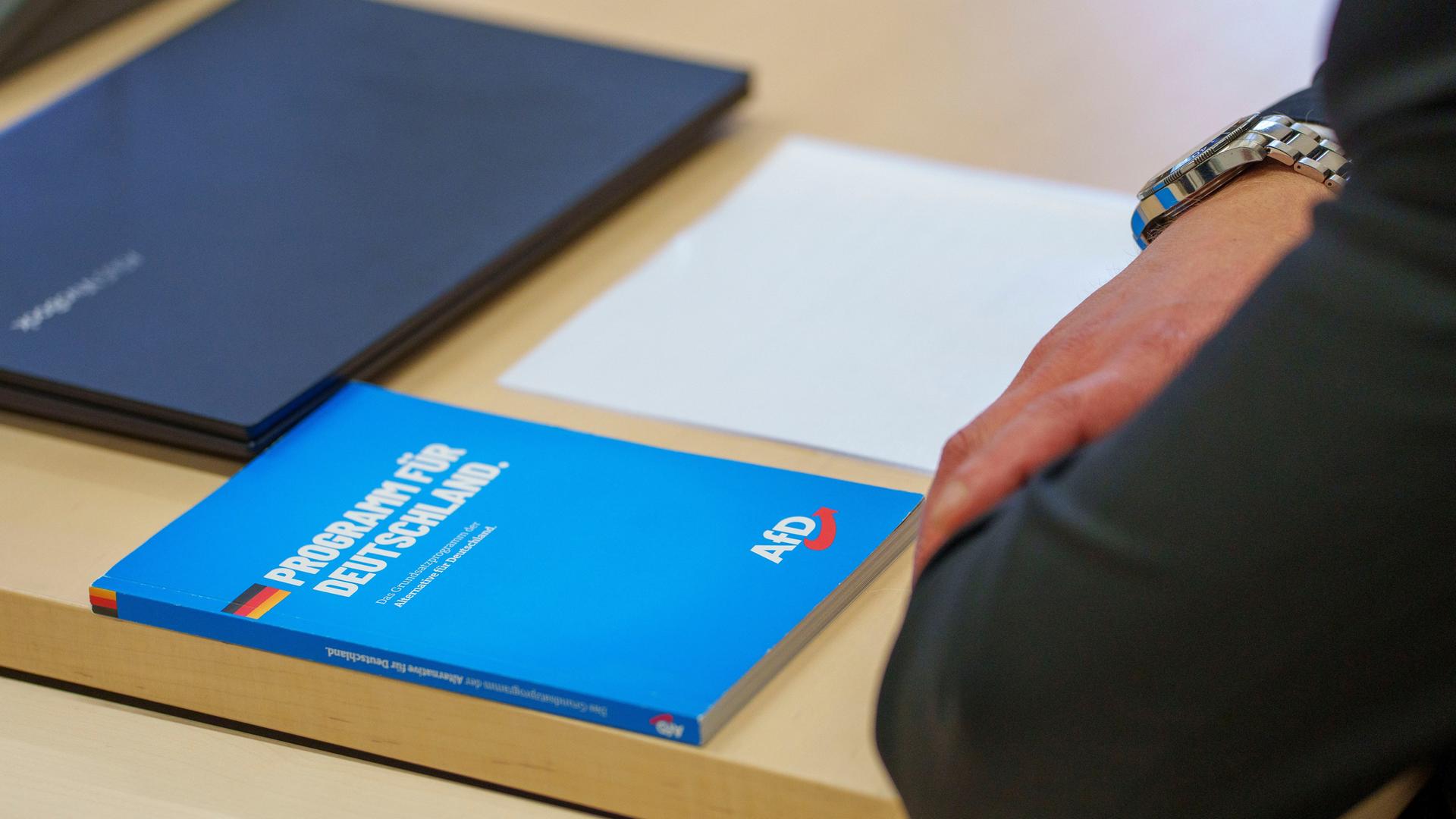 Ein "Programm für Deutschland" der AfD liegt vor Verhandlungsbeginn im Verwaltungsgericht im Gerichtssaal auf dem Tisch eines AfD-Vertreters. 