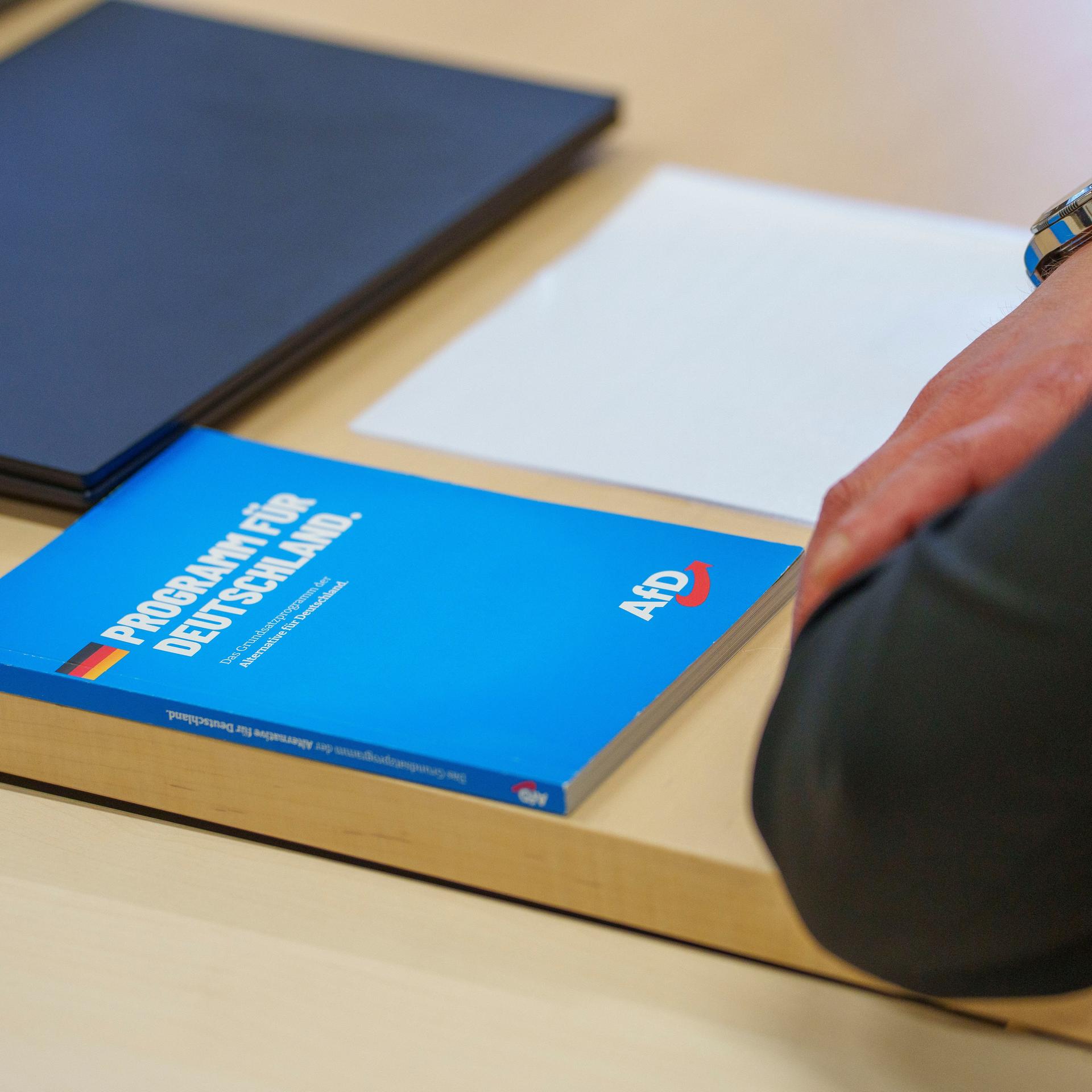 Ein "Programm für Deutschland" der AfD liegt vor Verhandlungsbeginn im Verwaltungsgericht im Gerichtssaal auf dem Tisch eines AfD-Vertreters. 