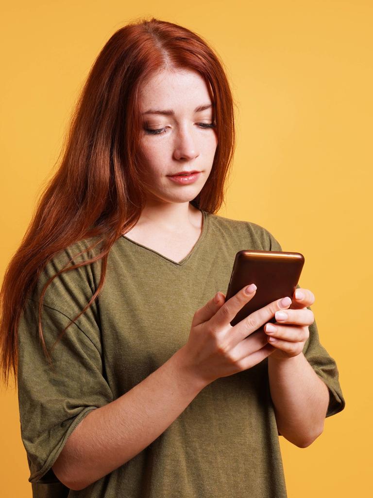 Junge Frau, die etwas auf ihrem Smartphone liest