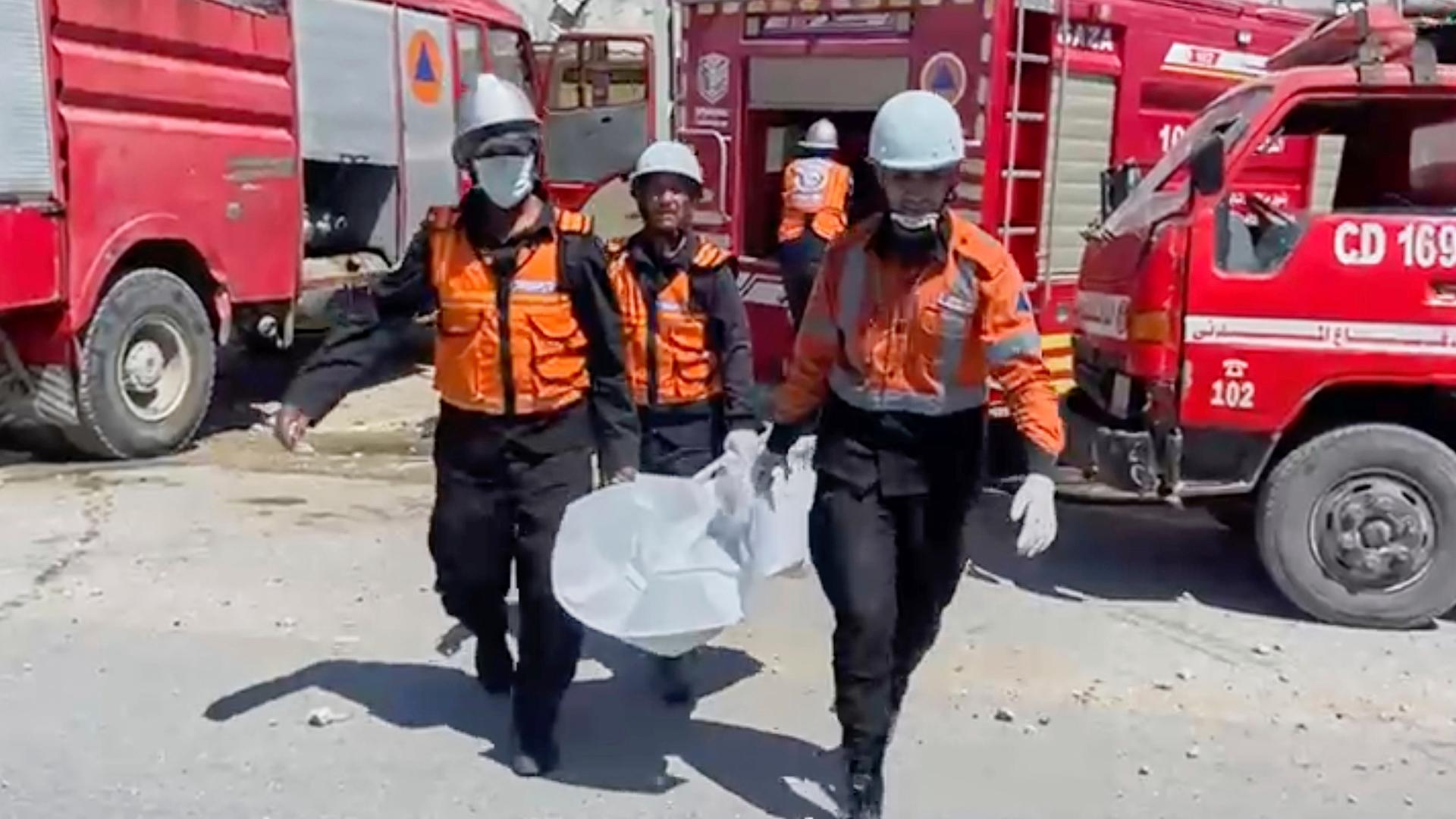 In diesem Ausschnitt eines von der Zivilverteidigung des Gazastreifens veröffentlichten Videos bergen Rettungshelfer menschliche Überreste, nachdem bei einem israelischen Angriff in Chan Younis offenbar neun der zehn Kinder einer Ärztin getötet wurden. In diesem Ausschnitt eines von der Zivilverteidigung des Gazastreifens veröffentlichten Videos bergen Rettungshelfer menschliche Überreste, nachdem bei einem israelischen Angriff in Chan Younis offenbar neun der zehn Kinder einer Ärztin getötet wurden.
