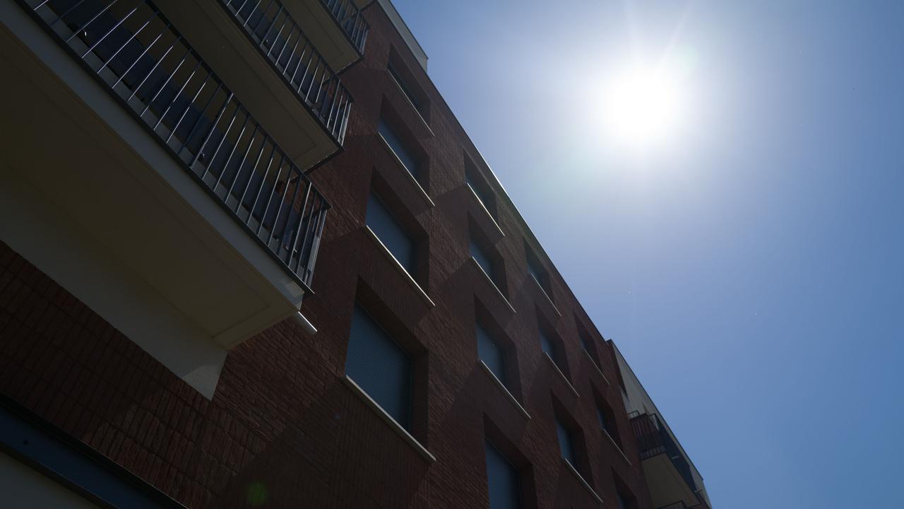 Die Sonne brennt auf ein Gebäuden mit Mitwohnungen herab.