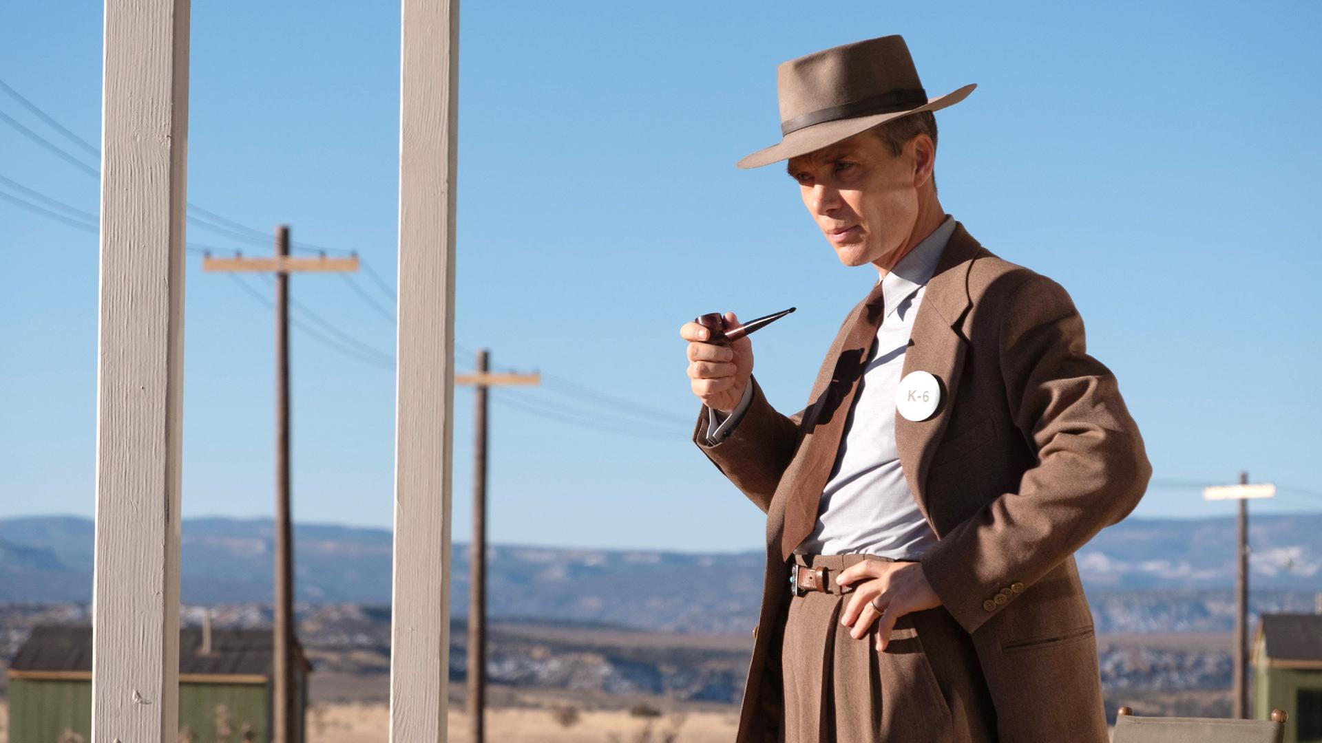 Cillian Murphy als J. Robert Oppenheimer im Film "Oppenheimer". Er trägt einen Anzug, einen Hut und hält eine Pfeife in der Hand.