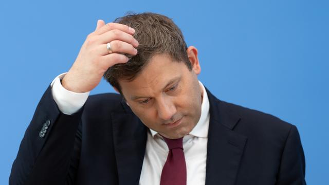 Lars Klingbeil (SPD), Bundesminister der Finanzen, bei einer Pressekonferenz. Er kratzt sich am Kopf. Der Hintergrund ist blau.