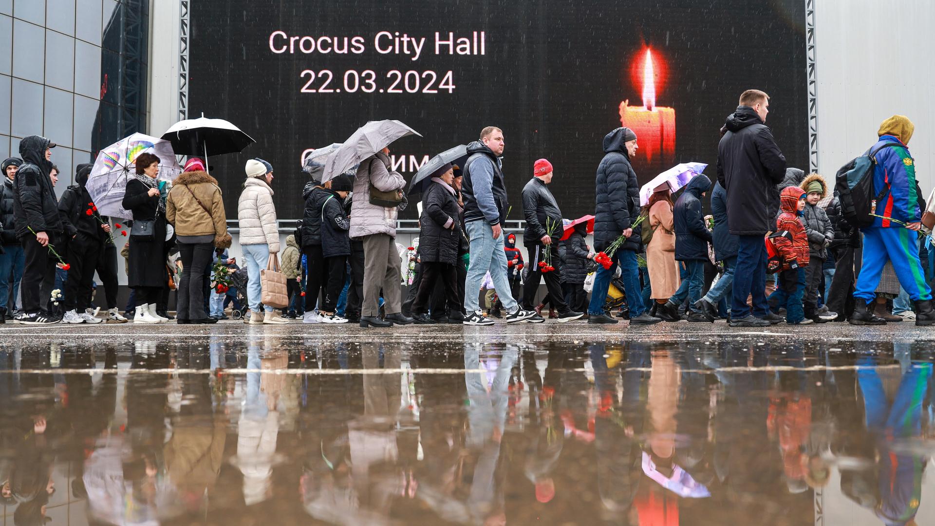 Menschen bringen Blumen und Kerzen zur Crocus City Hall nahe Moskau. DIESES FOTO WIRD VON DER RUSSISCHEN STAATSAGENTUR TASS ZUR VERFÜGUNG GESTELLT. 